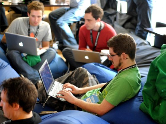 man sitting on blue bean bag usinglaptop