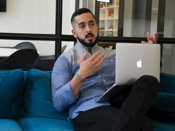 a man sitting on a couch holding a laptop