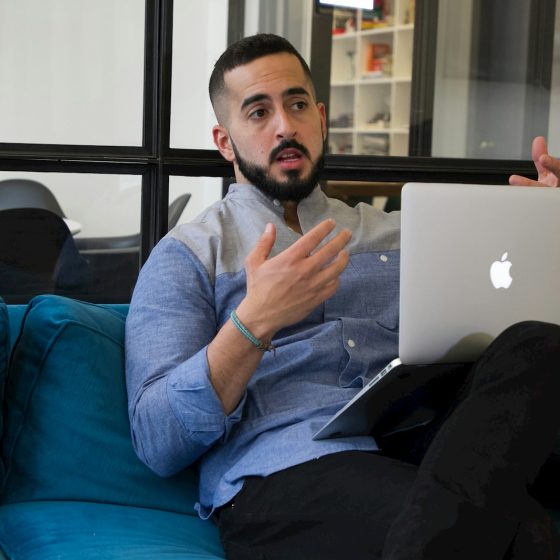 a man sitting on a couch holding a laptop